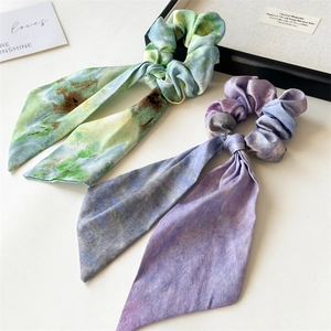 Detailed macro view of satin hair scrunchies with long ribbons and artistic marble textures