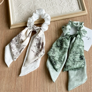 French style satin floral scrunchies with long ribbons on a minimalist wooden background