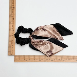 Floral satin scrunchie with long ribbons showing dimensions with a wooden ruler
