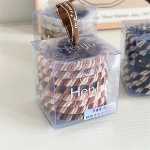 Detailansicht der elastischen Spiral-Haargummis im transparenten Geschenkkarton