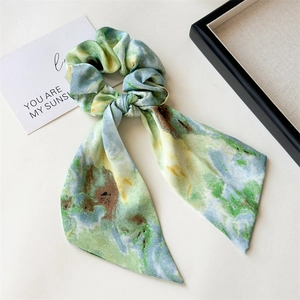 Detailed macro view of an artistic oil painting style silk scrunchie with colorful ribbons