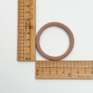 Macro shot of high-elastic pink hair tie showing 4.5cm outer diameter on measuring ruler
