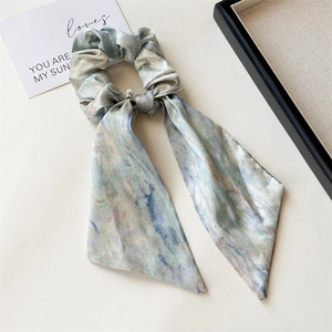 Detail of silk satin ribbon hair tie with watercolor marble print in soft pastel colors