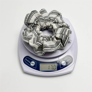 Weight measurement of a striped oversized scrunchie showing 17.0g on a digital scale