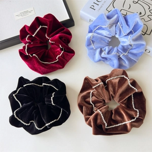 Detailed view of velvet scrunchies with rhinestone chains in red, blue, black and brown