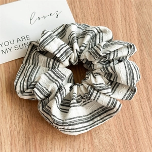 Detailed view of striped scrunchie fabric texture on light wood background
