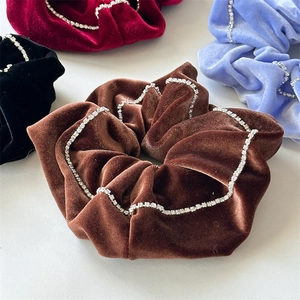 Detailed view of luxury velvet hair scrunchies with sparkling rhinestone chain edges