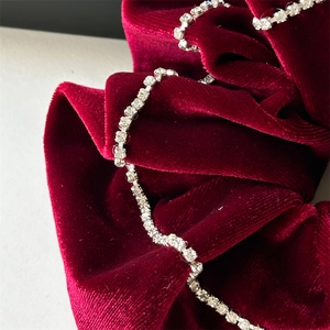 Luxurious burgundy velvet scrunchie with sparkling rhinestone chain wrap detail