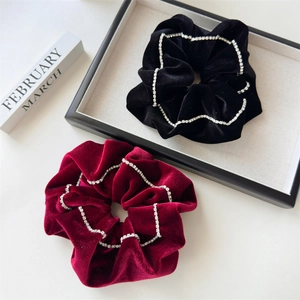 Detail showing plush velvet scrunchies with sparkling rhinestone edges in black and burgundy