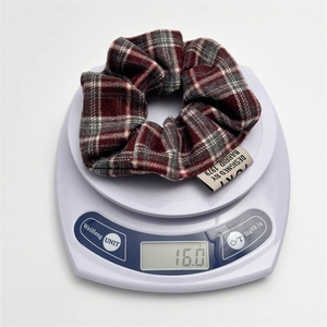 Macro shot of 16.0g red and grey plaid scrunchie weight measurement on scale