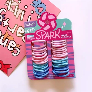 Dettaglio degli elastici per capelli SPARK rosa e blu su una confezione in cartone pro