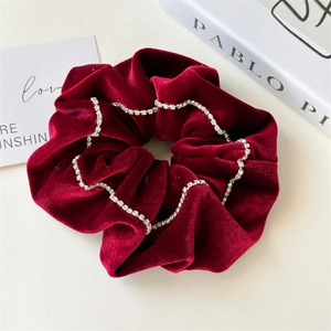 Detailed texture of burgundy velvet scrunchie decorated with sparkling rhinestones