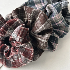 Close-up of vintage plaid flannel scrunchies showing detailed sewing and soft fabric texture