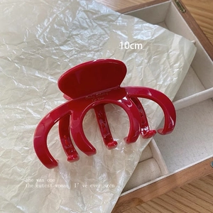 Detailansicht der 10cm roten Haarklammer mit goldener Aufschrift auf Holzdisplay