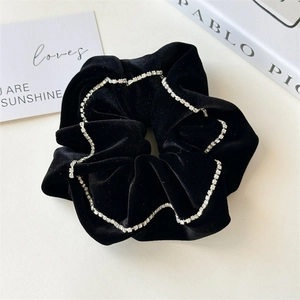 Detail of elegant black velvet hair scrunchie with sparkling rhinestone chain trim