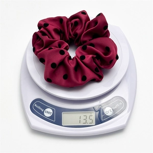 Burgundy satin scrunchie with black polka dots on white scale weighing 13.5g