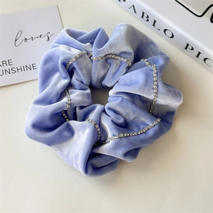 Detailed macro view of lilac velvet scrunchie featuring elegant rhinestone chain accents
