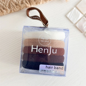 Vue détaillée de cinq élastiques à cheveux aux tons terreux dans un coffret cadeau