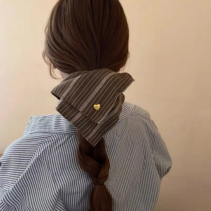 Detail of coffee striped hair scarf with heart charm tied on a ponytail
