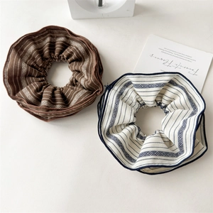 Detail of retro striped fabric scrunchies in brown and beige with boho diamond patterns