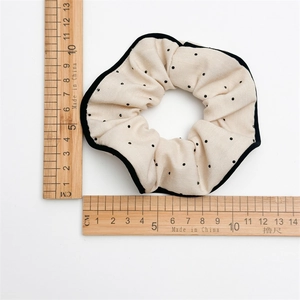 Beige polka dot fabric scrunchie with black trim showing 10-11cm diameter measurement