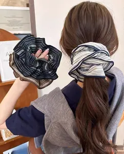 Detail of bohemian striped scrunchies showing glossy fabric and voluminous hair styling