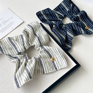Striped fabric hair scrunchies with golden heart pendants in beige and dark blue