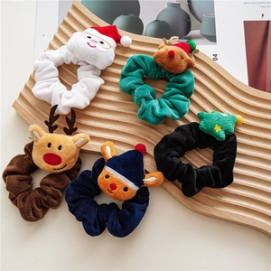 Set of five Christmas velvet scrunchies with plush reindeer and santa claus figures