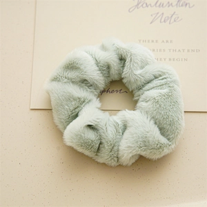 Dettaglio dell'elastico per capelli verde menta con texture in morbida pelliccia sintetica