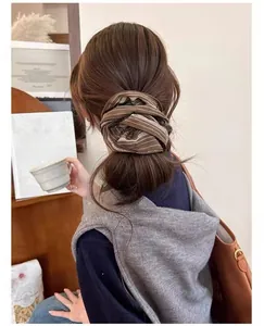 Close-up of retro striped fabric scrunchie worn on a ponytail in a cozy setting