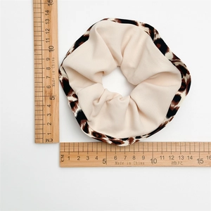 Leopard print polyester scrunchie with high elasticity shown with measurement tools