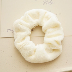 Dettaglio di un elastico per capelli in peluche bianco con morbida ecopelliccia