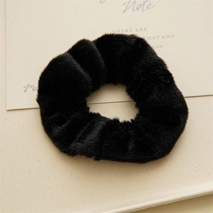 Dettaglio di un elastico per capelli in finta pelliccia nera morbida con trama soffice
