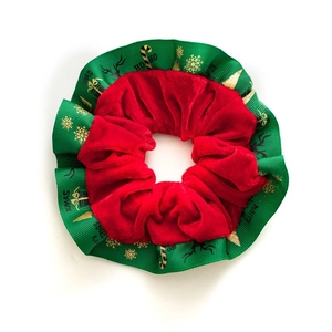 Detail of velvet Christmas scrunchie with festive gold snowflake and XMAS pattern prints