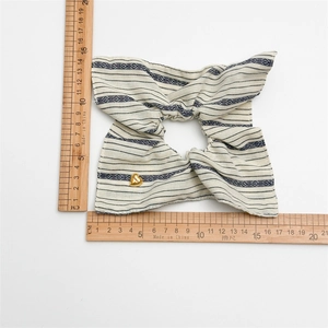 Blue and white striped scrunchie with golden heart charm and oversized bow design