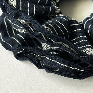 Retro striped fabric scrunchie with navy and white patterns and wavy stitched edges