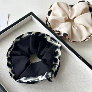 Close-up of leopard print ruffle hair scrunchies showing thick knitted fabric texture