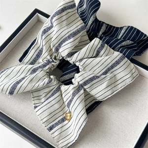 Detailed shot of striped hair scrunchies featuring heart charm on fabric texture