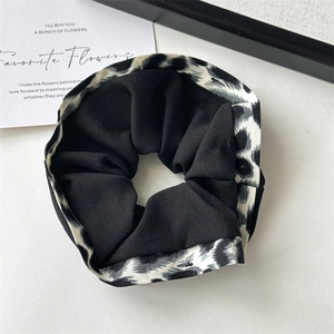 Detailed view of leopard print hair scrunchie with layered fabric and elastic band