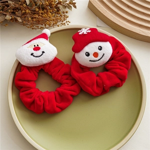 Detailed view of red velvet Christmas scrunchies with Santa and snowman plush characters