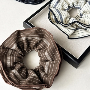 Detailed texture of fabric hair scrunchies with retro striped and geometric patterns
