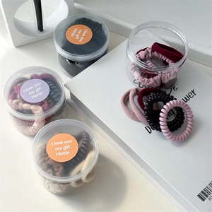 Detail of multi-pack spiral hair ties and scrunchies stored in clear round containers
