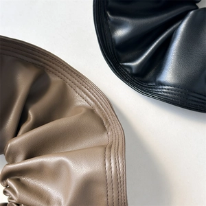Gros plan sur les chouchous en cuir noir et marron avec coutures multicouches élégantes