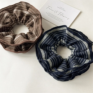 Detail of two-piece striped cotton scrunchies set in brown and navy blue colors