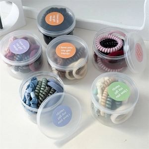 Set of 10 minimalist spiral telephone cord hair ties in a clear round plastic storage jar
