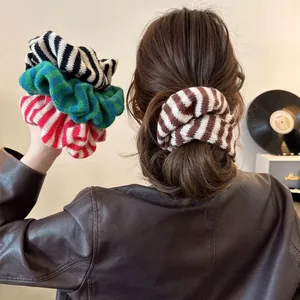 Close-up of four colorful striped knitted hair scrunchies with soft texture