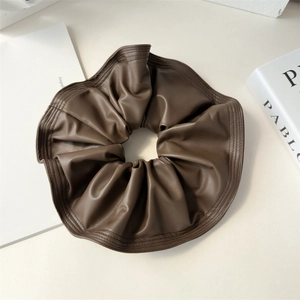 Détail macro du chouchou en cuir PU marron foncé avec couture fine et finition texturée