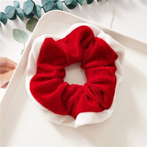 Detail of red and white velvet Christmas scrunchie on a tray with festive decoration