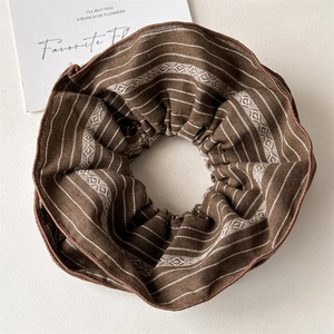 Close-up of retro striped fabric scrunchie with coffee-colored geometric pattern
