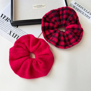 Close-up of red knit oversized scrunchies in solid magenta and plaid patterns